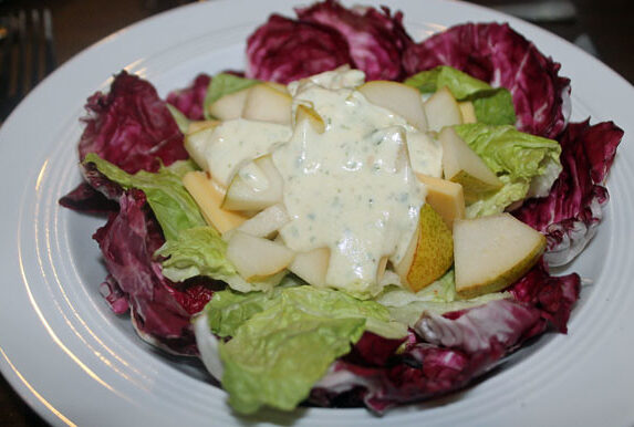 Käse und Birne auf einem Salatbett